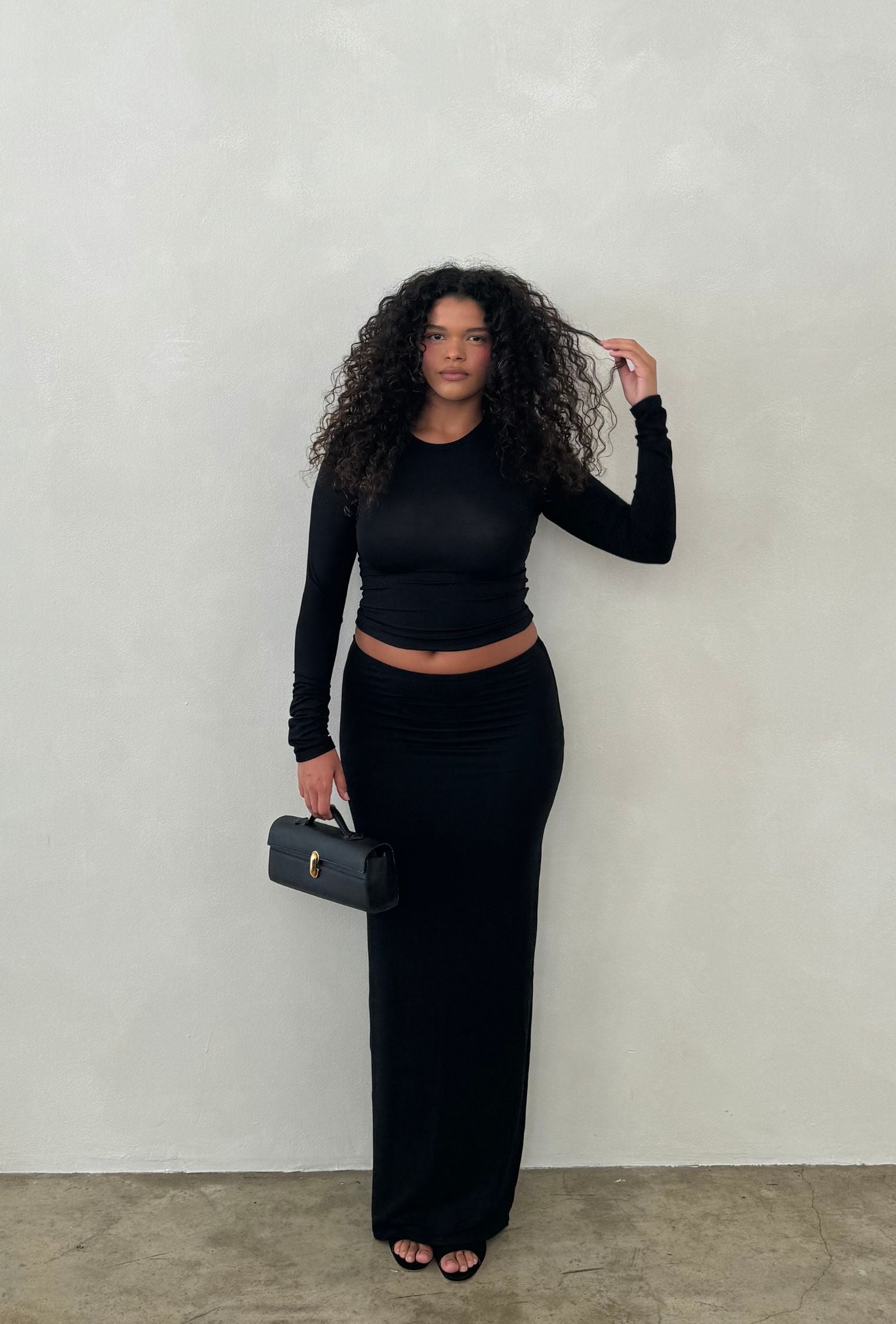 Black low-waisted maxi skirt styled a matching long sleeve