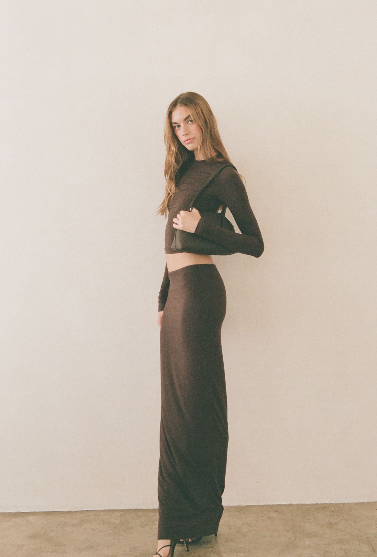 Brown low-waisted maxi skirt styled for an evening look