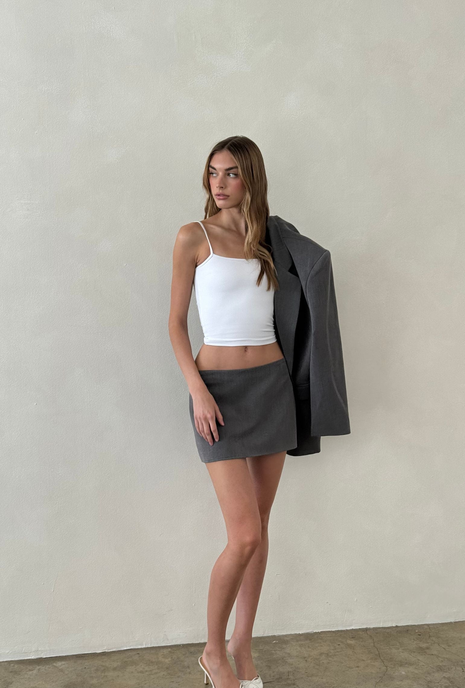 Gray tailored mini skirt styled with a white cropped tank and matching blazer