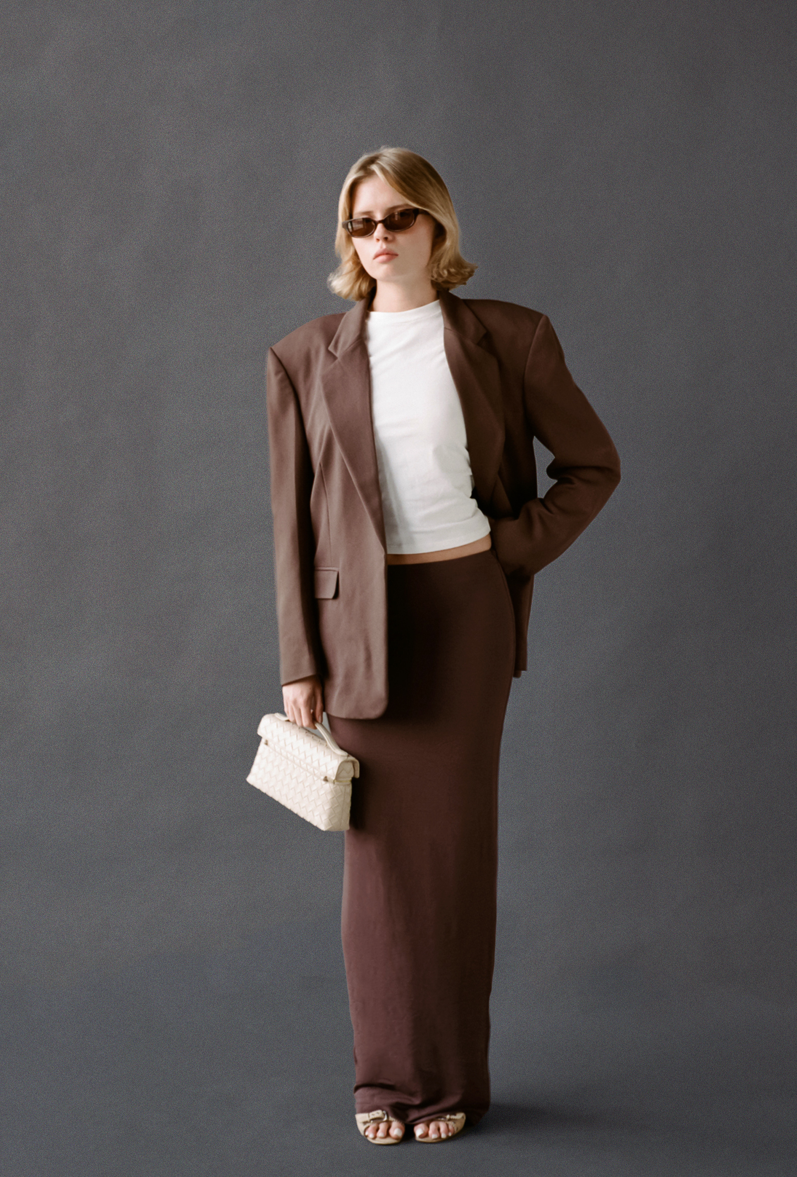 LAUD maxi skirt in brown styled with a white tee, brown blazer, and top handle bag